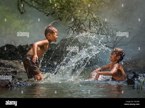 Asia children on river / The boy friend happy funny playing water in ...