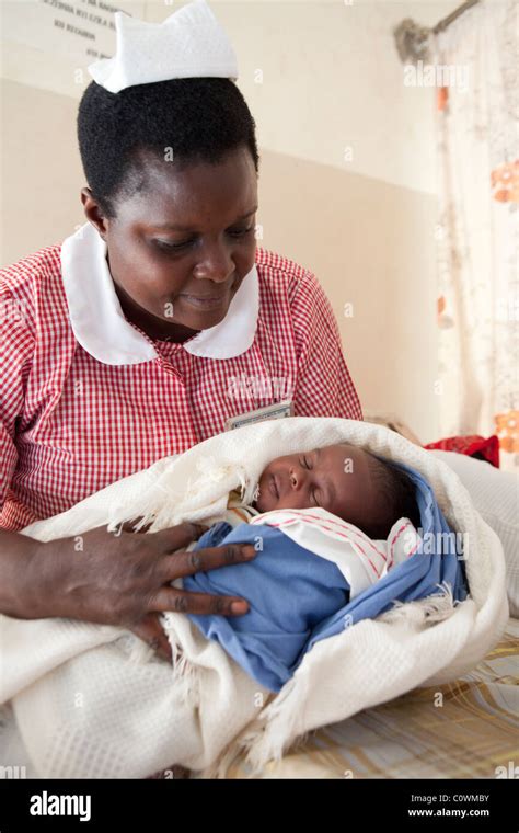 A nurse holds a newborn baby in a clinic in Jinja District, Uganda ...