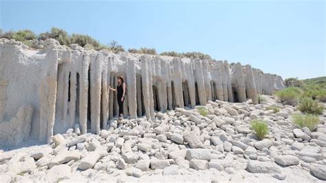 a woman standing between two large rock formations