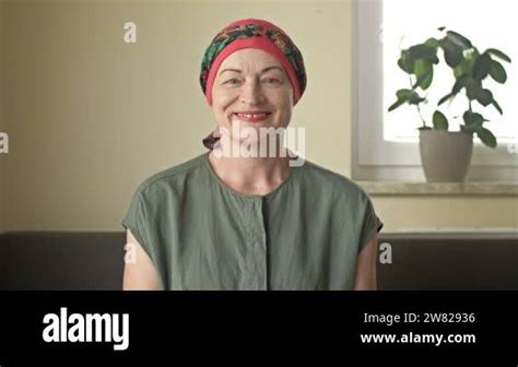 Portrait of a woman with cancer. She removes the scarf from her bald ...