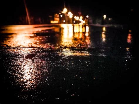 Premium Photo | Reflection of illuminated lights on wet road in rainy ...