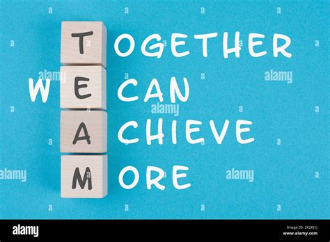 Team, together we can achieve more is standing on wooden cubes ...