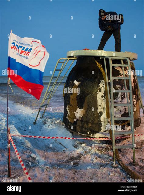 A photographer stands atop the Soyuz TMA-05M spacecraft long after it ...