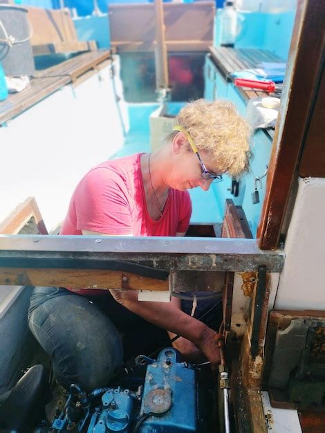 Premium Photo | Woman repairing motor in boat