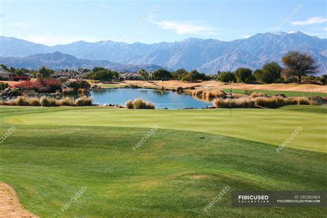 Amazing green lawn at golf course and scenic mountains on horizon at ...