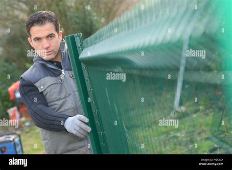 Installing a metal fence Stock Photo - Alamy