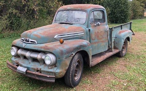 an old rusty truck parked in the grass