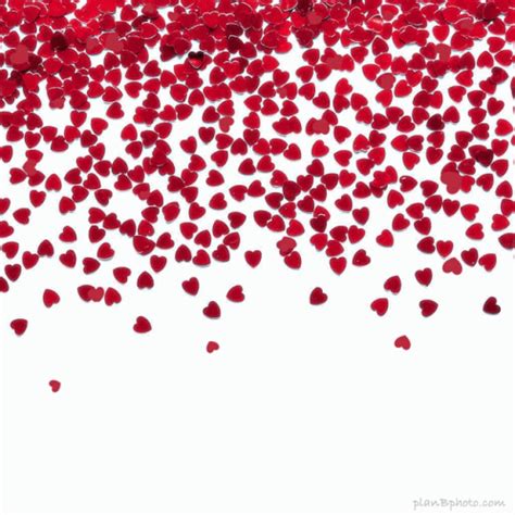 red heart shaped confetti on white background