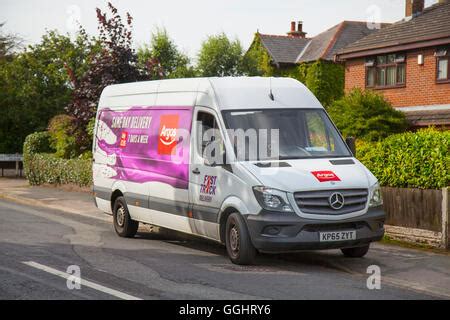 Argos home delivery van in a street with rear door open and man ...