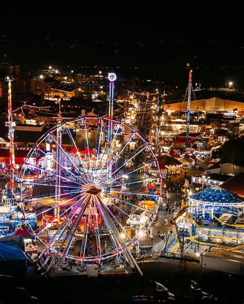 an aerial view of a carnival at night with ferris wheel in the ...