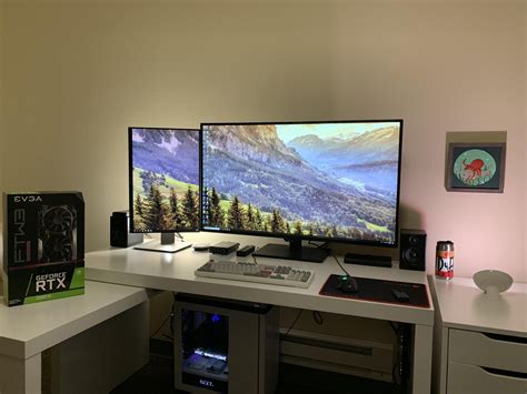 two computer monitors sitting on top of a white desk next to a keyboard ...