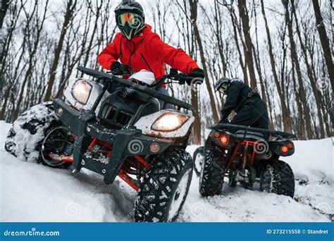 On the Off Road. Two People are Riding ATV in the Winter Forest Stock ...