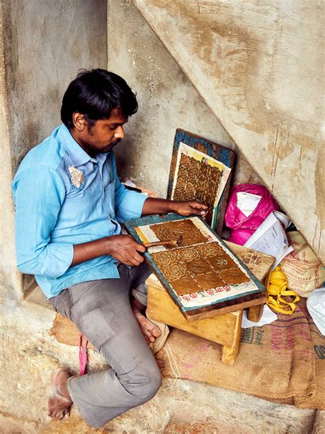 A shopkeeper crafting copper yantras in a small corner at Puthu ...