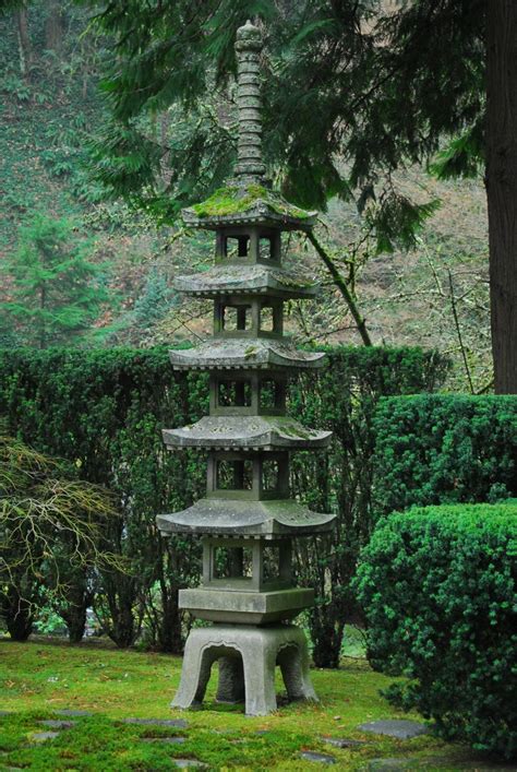 a tall stone pagoda sitting in the middle of a lush green park