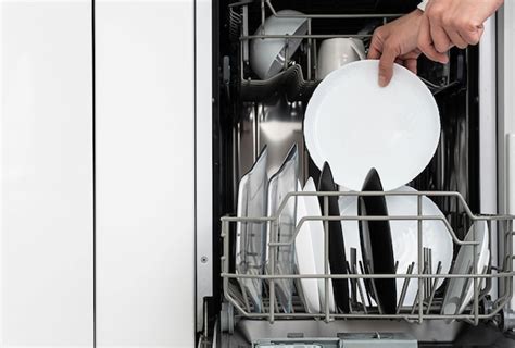 Premium Photo | Woman doing dishes in dishwasher at home