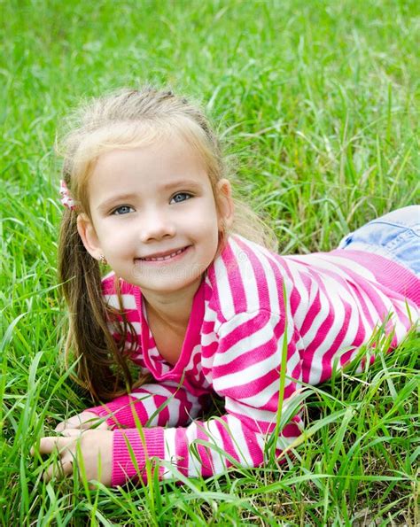 Cute Smiling Little Girl Lying In Grass On The Meadow Stock Image ...