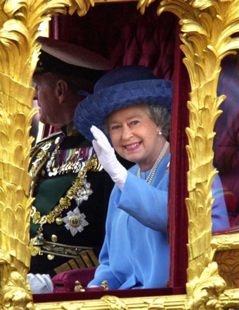 June 4, 2002 Queen Elizabeth II waving to the crowd as she rides in the ...