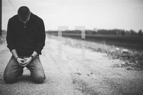 Man kneeling in prayer in the middle of a rural... — Photo — Lightstock