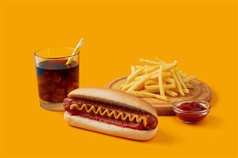 Premium Photo | Hot dog with french fries and soft drink on orange ...