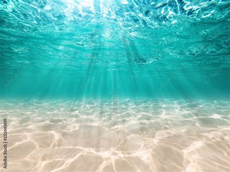 underwater background deep blue sea and beautiful light rays with sandy ...