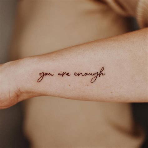 "You are enough" lettering tattoo on the wrist