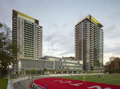 two tall buildings next to each other on a field in front of a soccer field