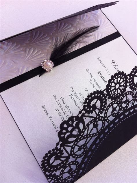 Black and white lace invitation with feather and buckle embellishments ...