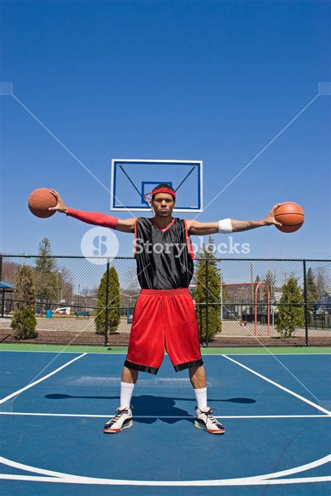 A young basketball player holding two basketballs. Royalty-Free Stock ...