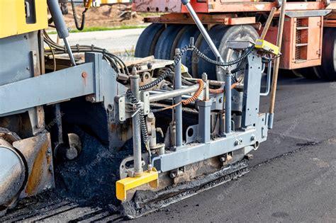 Premium Photo | Asphalt laying equipment work on the device of a new ...