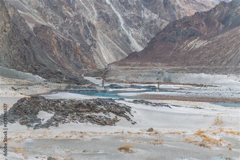 Far view of a hanging bridge over river. A Dried river trail of Shyok ...