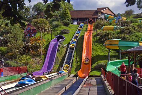 people are riding on water slides at an amusement park