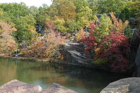 a pond surrounded by rocks and colorful trees