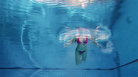 Beautiful Woman In A Pink Bikini Diving In And Swimming Underwater ...