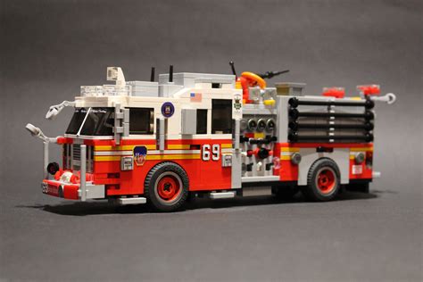 a toy fire truck is shown on a gray surface