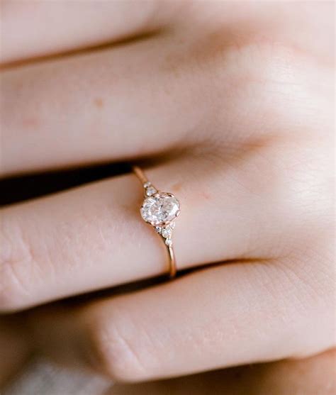 a woman's hand with a diamond ring on top of her finger, showing the ...