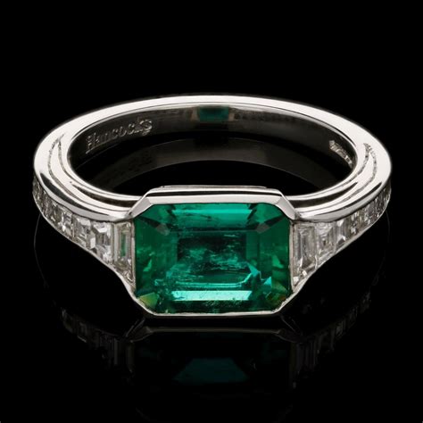 An elegant Colombian emerald ring set in platinum with calibre step-cut ...