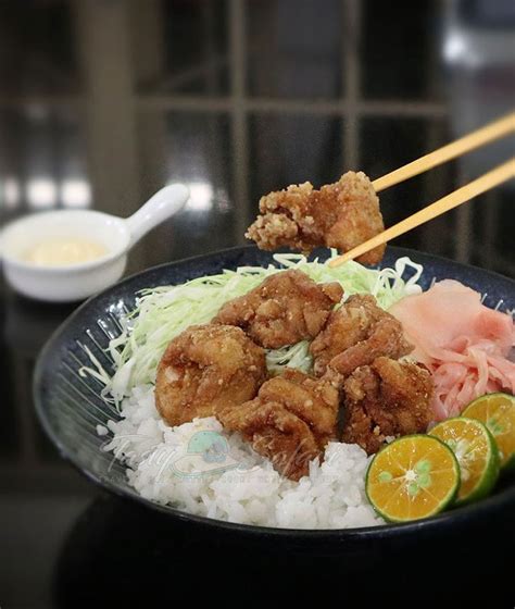 a bowl filled with rice, meat and veggies next to chopsticks