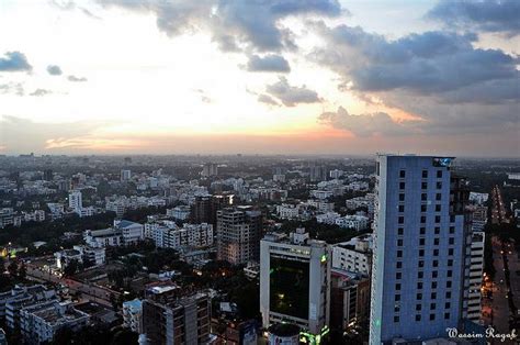 an aerial view of a city at sunset with clouds in the sky and buildings ...