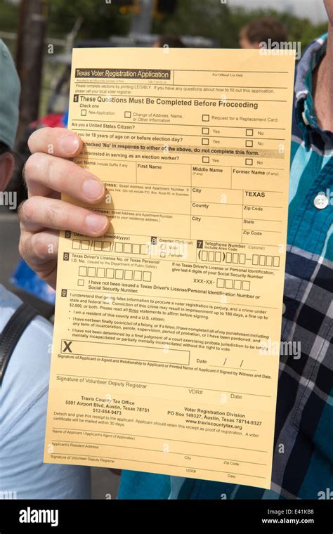 Man holds up a Texas Voter Registration card during a Juneteenth parade ...