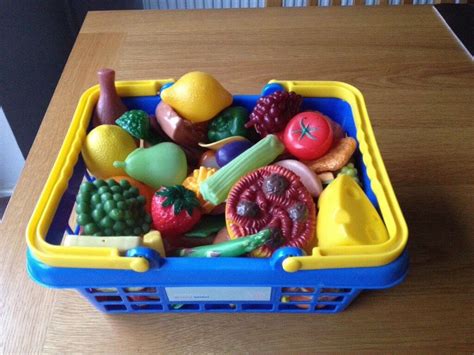 Basket full of plastic play kitchen food, including fruit, vegetables ...