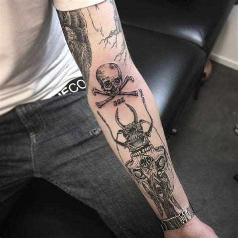 Skull and crossed bones tattoo on the arm - Tattoogrid.net