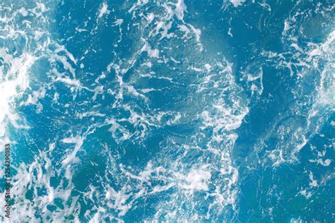 bright blue surface of ocean water with white foam, background, texture ...