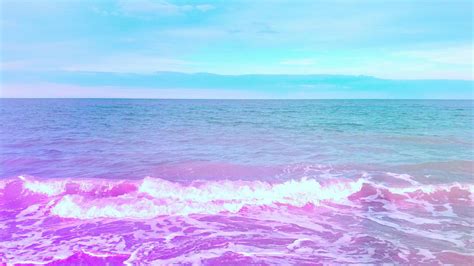 the ocean is pink and blue with white waves