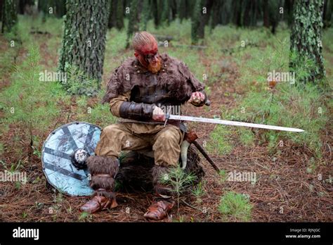 Real viking sharpening his sword with a stone. Ready for the fight ...