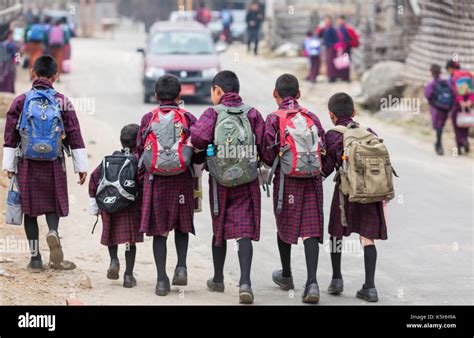 Schoolchildren on their way to the town school wearing traditional ...