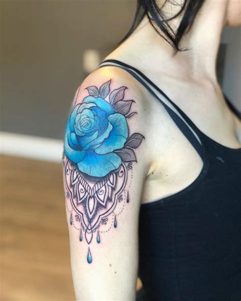 a woman with a blue rose tattoo on her arm