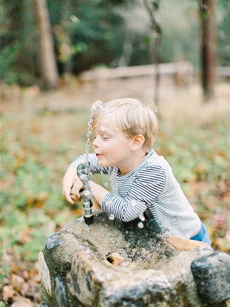 "Young Boy Drinking From Water Fountain" by Stocksy Contributor "Ali ...