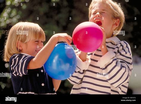 portrait of kids blowing up balloons Stock Photo - Alamy