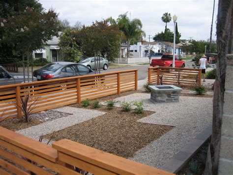 a wooden bench sitting in the middle of a park next to a street with ...