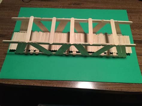 a wooden bridge on top of a green mat next to a computer mouse and keyboard